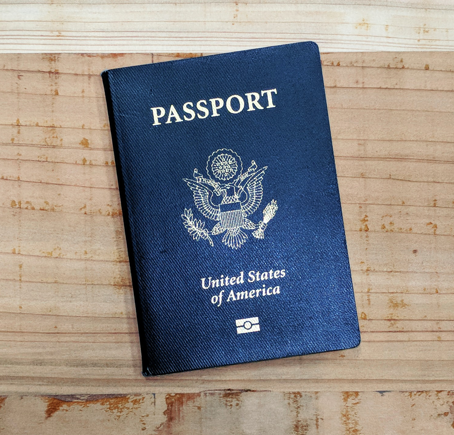 Blue United States Passport booklet on wooden table top